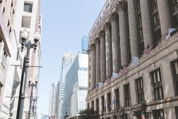 View of imposing courthouse and office buildings along a city street, showcasing the prime location for law firms and the convenience of nearby coworking spaces for legal professionals.