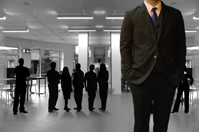 Modern coworking space designed for legal professionals, featuring a group of lawyers in silhouette against the backdrop of a spacious, well-lit office environment with contemporary furnishings.