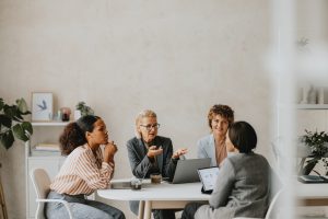 A diverse group of business professionals engaged in a meeting at a modern office, discussing Virtual Office Solutions.